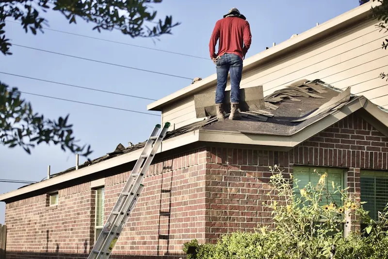 Professional roofer working on a residential roof in Montgomery Brooke